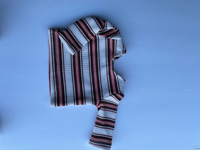 May include: A white, pink, and black striped long-sleeve shirt.