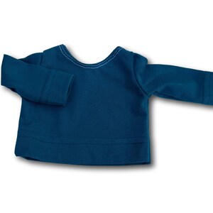 K&ouml;nnte beinhalten: Ein lang&auml;rmliges Shirt in Tealblau mit einem runden Ausschnitt. Das Shirt ist aus weichem, dehnbarem Stoff.