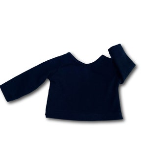 K&ouml;nnte beinhalten: Ein schwarzes Langarmshirt mit einem runden Ausschnitt.