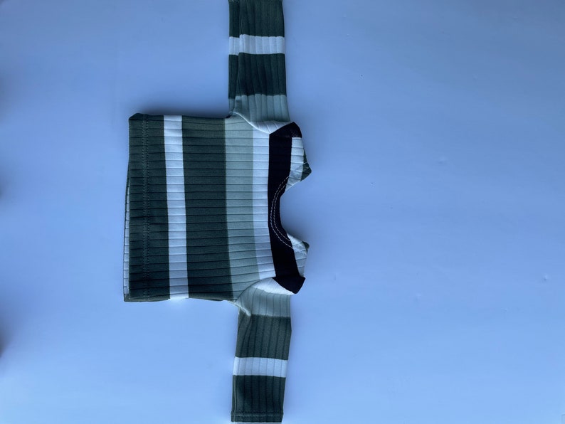 May include: A long-sleeved shirt with white and green stripes and a black collar.
