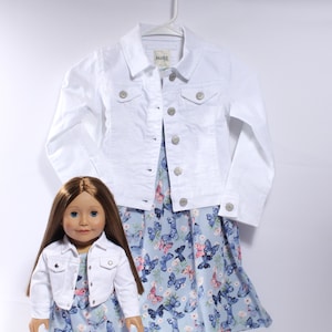 May include: A white denim jacket with a blue and white butterfly print dress. The jacket has a button closure and two pockets. The dress has a scoop neck and a flowy skirt.