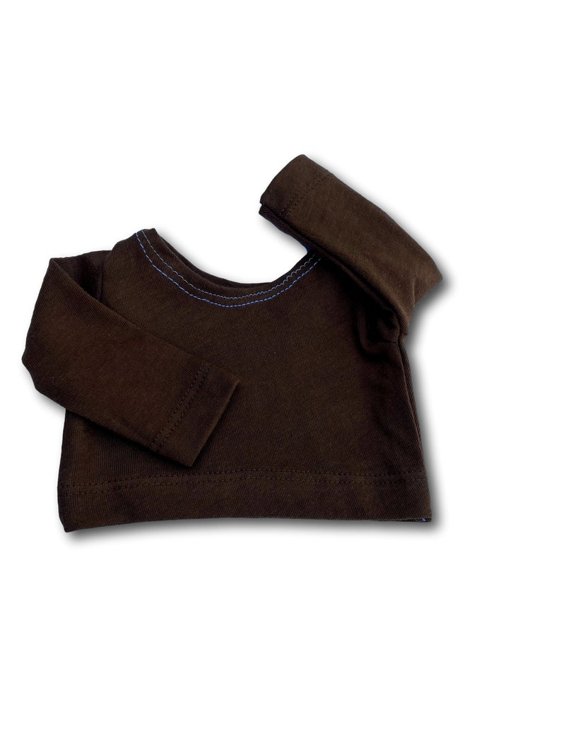 K&ouml;nnte beinhalten: Ein braunes Langarmshirt mit einem blauen Stichdetail am Ausschnitt.