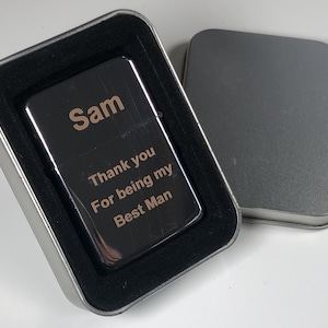 May include: A silver lighter with a personalised message engraved on it. The message reads "Sam Thank you For being my Best Man". The lighter is in a black velvet gift box.