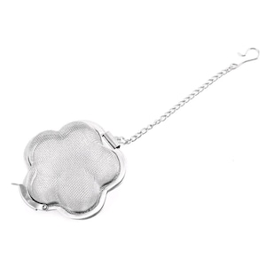 May include: A silver tea infuser shaped like a four-leaf clover. The infuser has a fine mesh and is attached to a chain with a hook. This tea strainer is designed for loose tea leaves. The infuser is made of metal.