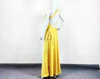 May include: A yellow maxi dress with a one-shoulder design and a criss-cross back detail.