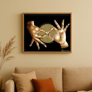 Può includere: Opera d'arte incorniciata con due mani che formano un cerchio attorno a una ruota color oro su sfondo nero. Le parole "dharma chakra wheel" sono scritte sull'opera d'arte. L'opera d'arte è in una cornice color oro.