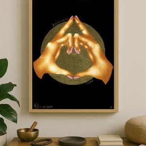 Può includere: Opera d'arte incorniciata con due mani che formano un cuore, con smalto rosa. Lo sfondo è nero con un cerchio dorato. L'opera include il testo "kalesvara" e "Time".