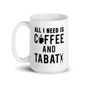 May include: White ceramic coffee mug with the text "ALL I NEED IS COFFEE AND TABATA" in black. The design includes a coffee cup icon and a silhouette of a person lifting weights. A perfect gift for coffee and fitness lovers.