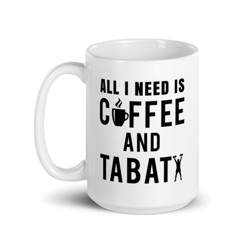 May include: White ceramic coffee mug with the text "ALL I NEED IS COFFEE AND TABATA" in black. The design includes a coffee cup icon and a silhouette of a person lifting weights. A perfect gift for coffee and fitness lovers.