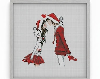May include: Cross-stitch artwork in a gray frame depicts a couple in Santa hats and red coats, about to kiss. A red heart floats above their heads. The artwork is on a white background.