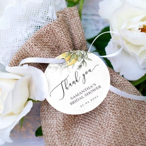 Puede incluir: Una etiqueta redonda blanca de agradecimiento con una ilustración de acuarela de limones y vegetación. La etiqueta dice "Gracias" en cursiva y "Samantha's Bridal Shower 25.04.2023".