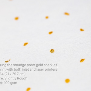 May include: White cardstock paper with gold glitter embedded in the paper. The paper is A4 size (21 x 29.7 cm), slightly rough, and weighs 100 gsm. The text on the paper reads: "Featuring the smudge proof gold sparkles Can print with both inkjet and laser printers Size: A4 (21 x 29.7 cm) Texture: Slightly Rough Weight: 100 gsm"