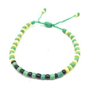 May include: A green, black, and yellow beaded bracelet with a green string closure.