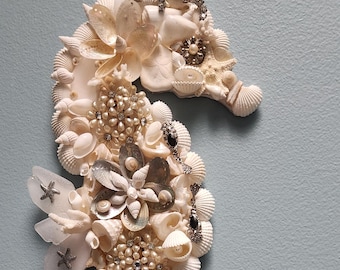 Mosaico de conchas e joias vintage com cavalo-marinho.