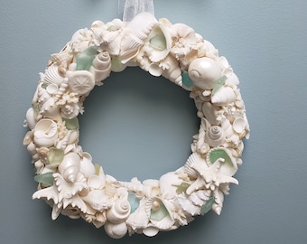 Coroa de conchas brancas com estrelas do mar e vidro marinho