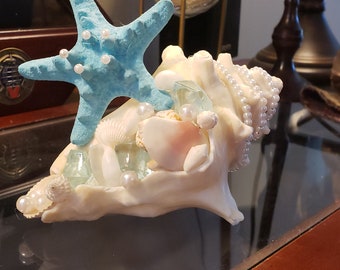 Topo de bolo de casamento em concha com pérolas e estrela do mar