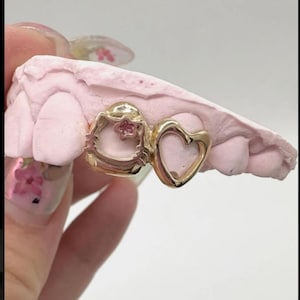 Fai una dichiarazione audace con la nostra griglia in argento placcato. Realizzata in materiale di alta qualità color oro, questa griglia accattivante