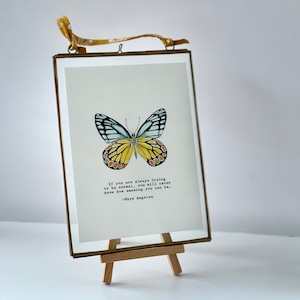 A hand painted and framed giclee print butterfly with vintage typed Maya Angelou quote “If you’re always trying to be normal….” other quotes