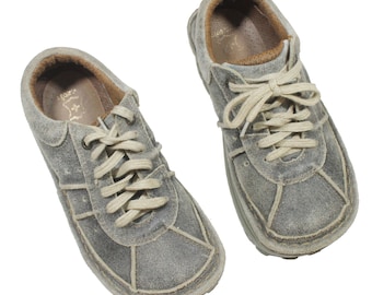 May include: A pair of gray suede sneakers with white laces. The sneakers have a distressed look and are worn.