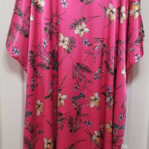 May include: A pink, long-sleeved, floral print kaftan with a V-neckline.