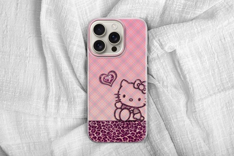 May include: Pink phone case with a plaid pattern, featuring a Hello Kitty design and a heart. The bottom section has a leopard print design. The case is designed for a smartphone.
