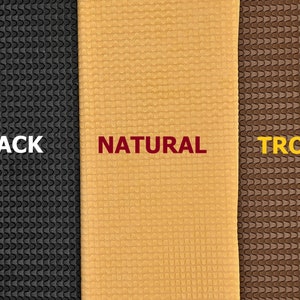 May include: Three samples of textured rubber material in black, natural, and brown colors. The text "BLACK", "NATURAL", and "TROPIC" is printed below each sample.