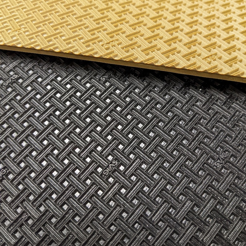 May include: Close-up of two textured surfaces. The top surface is a light brown with a grid pattern. The bottom surface is black with a similar grid pattern.