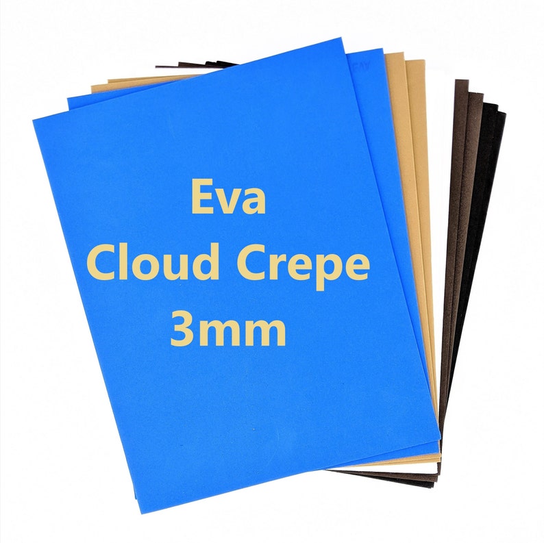 Pode incluir: Uma pilha de folhas de espuma artesanal azul, marrom e bege. A folha superior &eacute; azul e tem o texto "Eva Cloud Crepe 3mm" impresso nela.