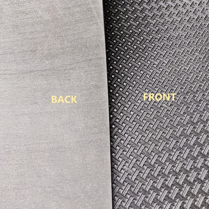 May include: A close-up of a black and grey mouse mat with a textured surface. The front side has a grid pattern, while the back side is smooth. The words "BACK" and "FRONT" are printed on the mat.