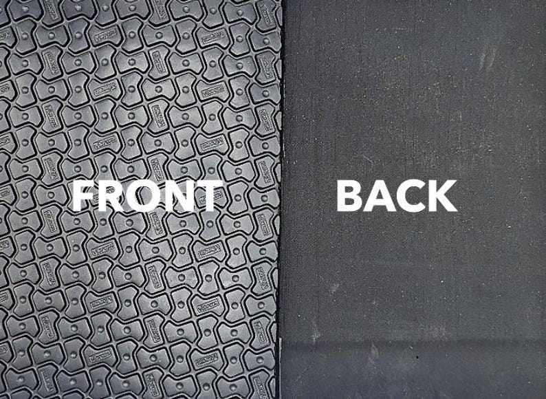 May include: Close-up of a black yoga mat with a textured surface. The front side of the mat has a pattern of small, raised squares. The back side of the mat is smooth. The words "FRONT" and "BACK" are printed on the mat.