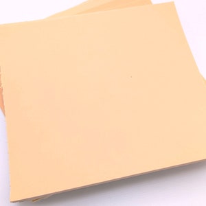 May include: A stack of light peach colored craft paper sheets.