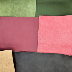 May include: A close-up of five different colored leather swatches. The swatches are arranged in a grid pattern. The colors are green, burgundy, pink, black, and tan.