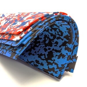 May include: Stack of blue, black, and red patterned foam sheets. The sheets are folded in half and stacked on top of each other.