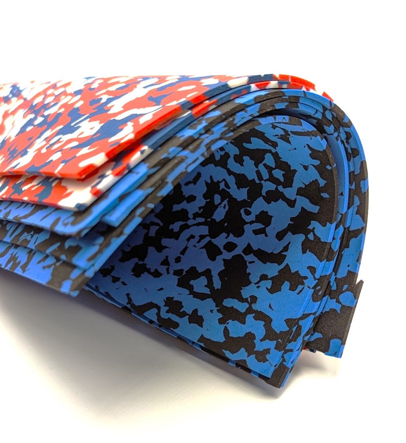 May include: Stack of blue, black, and red patterned foam sheets. The sheets are folded in half and stacked on top of each other.