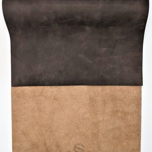 May include: A piece of brown leather with a tan suede backing. The suede side has a circular stamp that reads "Genuine Leather, Made in Italy".