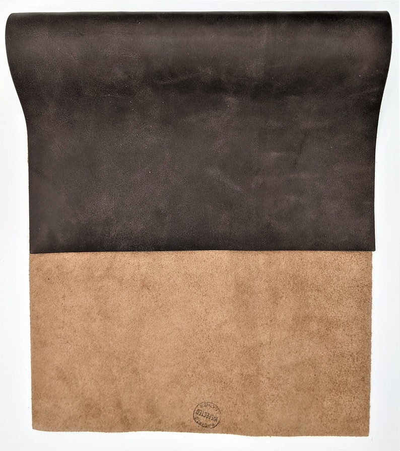 May include: A piece of brown leather with a tan suede backing. The suede side has a circular stamp that reads "Genuine Leather, Made in Italy".
