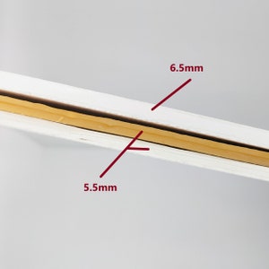 May include: Close-up of a white board with a yellow tape strip in the middle. The tape is 6.5 mm wide and the board is 5.5 mm thick.