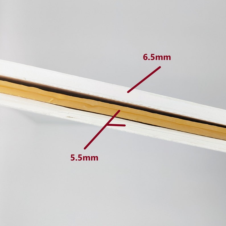 May include: Close-up of a white board with a yellow tape strip in the middle. The tape is 6.5 mm wide and the board is 5.5 mm thick.