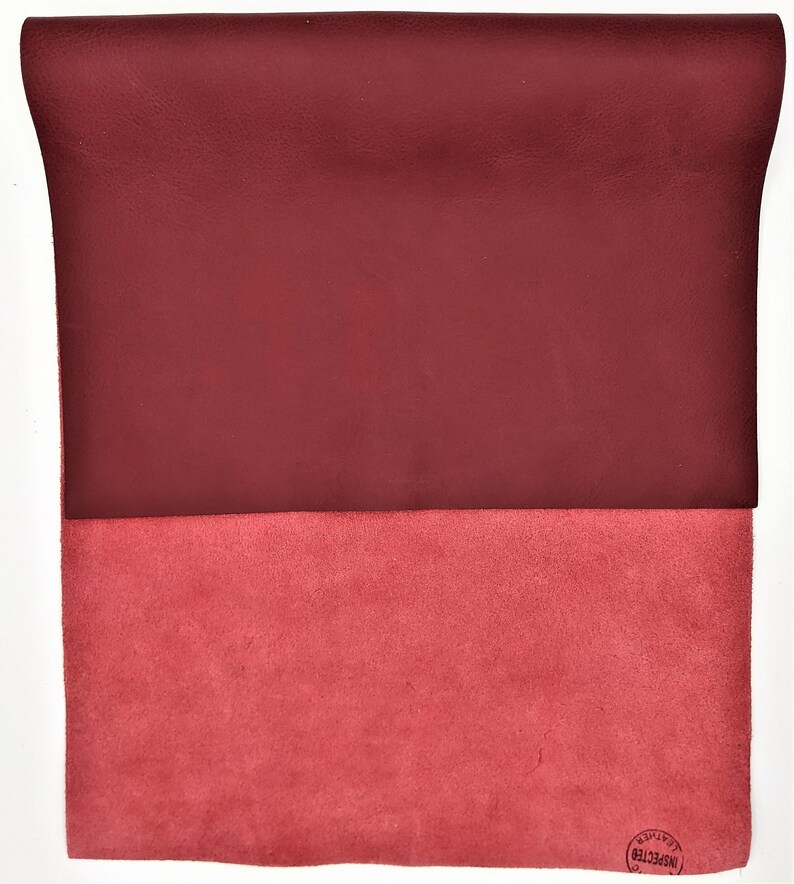 May include: A burgundy leather sheet with a suede underside. The suede side has a circular stamp that reads "INSPECTED".