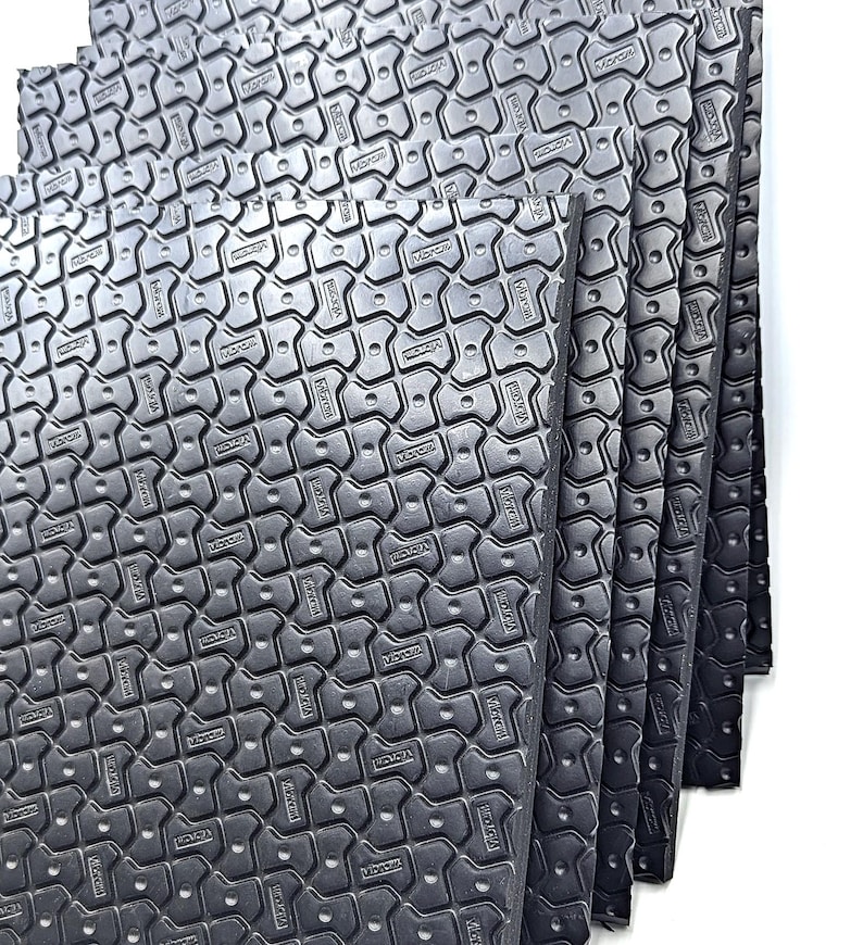 May include: A stack of six black foam mats with a textured surface. The mats have a repeating pattern of small, raised hexagons.
