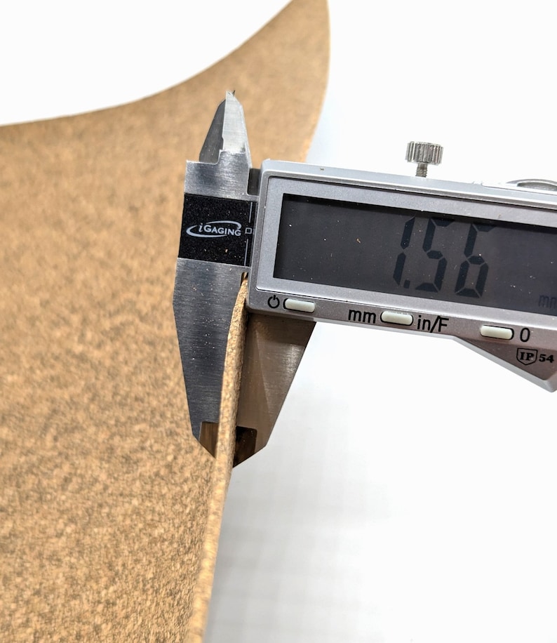 Puede incluir: Primer plano de un cuero marr&oacute;n con un calibre digital que mide el grosor del cuero. El calibre muestra 1,50 mm.