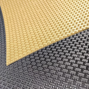 May include: Close-up of two textured surfaces. The top surface is a light gold colour with a diamond pattern. The bottom surface is black with a similar diamond pattern.