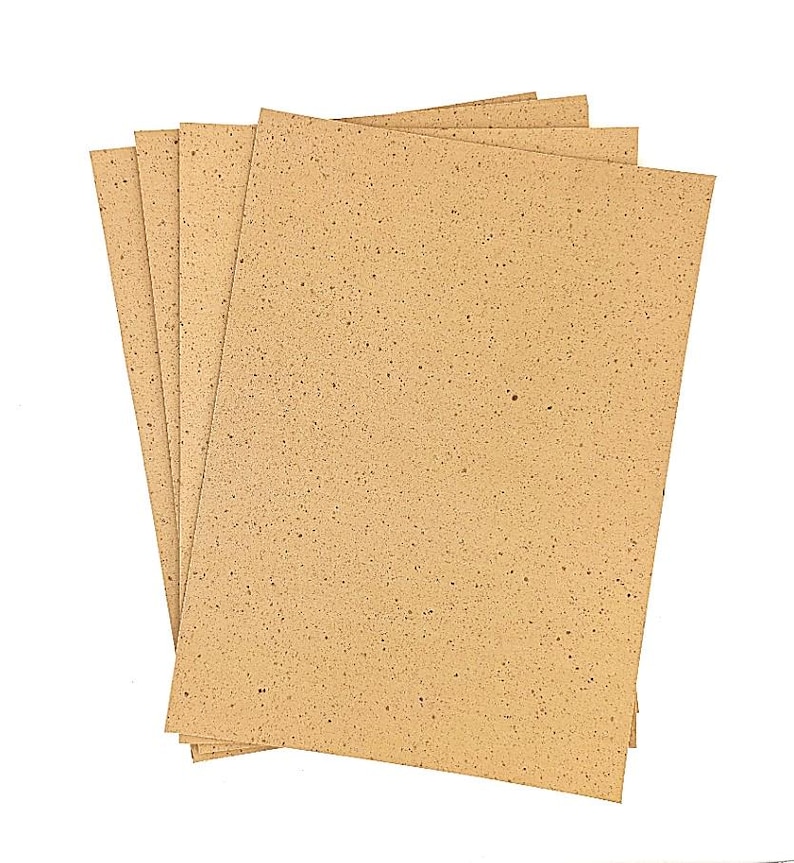 May include: A pile of rectangular, tan-coloured sheets of paper with a speckled pattern. The sheets are slightly fanned out, revealing their edges. The paper has a rough texture and a natural, earthy tone.