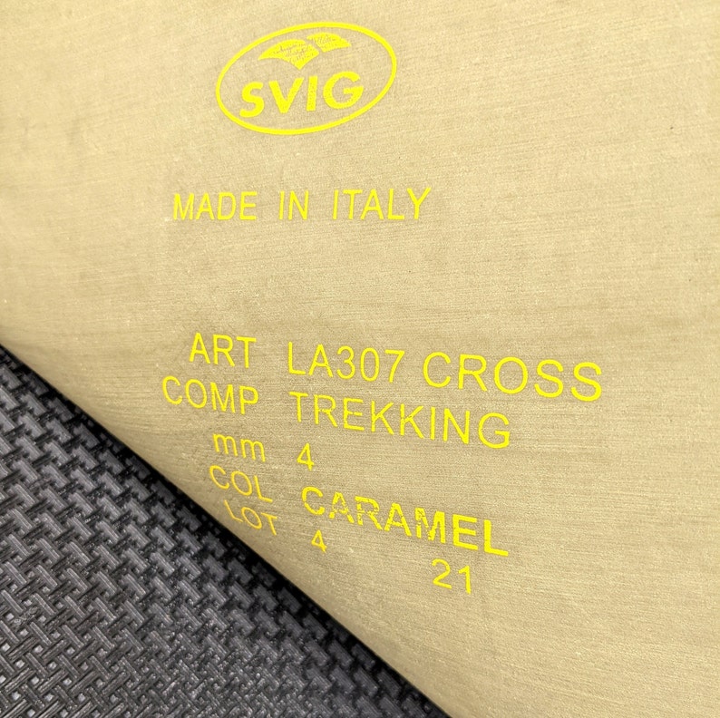 May include: A beige label with yellow text that reads "SVIG MADE IN ITALY ART LA307 CROSS COMP TREKKING mm 4 COL CARAMEL LOT 4 21".
