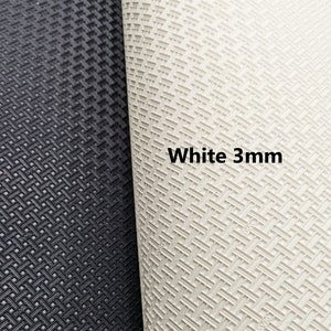 May include: Close-up of two sheets of textured rubber material. The sheet on the left is black and the sheet on the right is white. The white sheet has the text "White 3mm" printed on it.