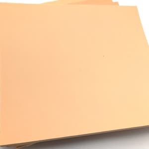 May include: A stack of peach-colored craft foam sheets.