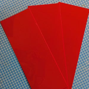 Può includere: Tre fogli di plastica acrilica rosso vivo.