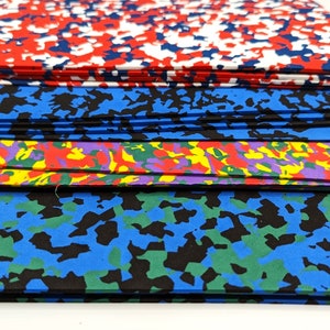 May include: Stack of colorful foam sheets with different abstract patterns. The top sheet is red, white, and blue. The second sheet is blue and black. The third sheet is purple, yellow, and red. The bottom sheet is blue, green, and black.