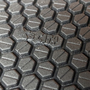 May include: Close-up of a black rubber outsole with a hexagonal pattern. The text "SCIT4" is embossed in the center of the outsole.