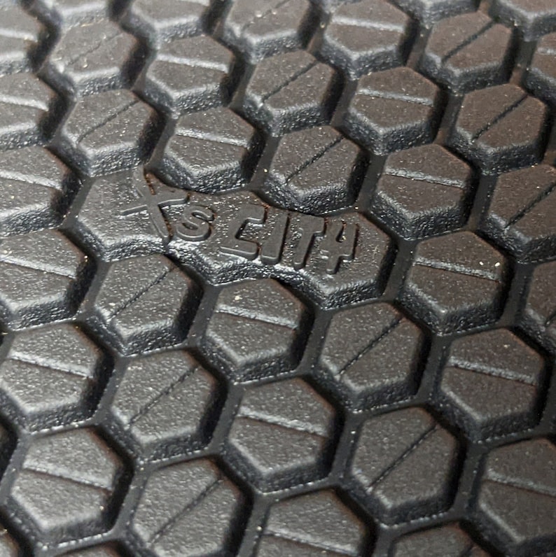 May include: Close-up of a black rubber outsole with a hexagonal pattern. The text "SCIT4" is embossed in the center of the outsole.